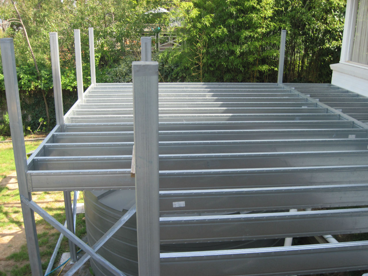 Boxspan steel deck frame over rainwater tank with posts to handrail height