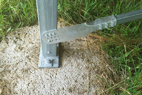 An Ezibrace Paddle fixed to an SHS post with screws above an Ezipier base on a concrete round footing