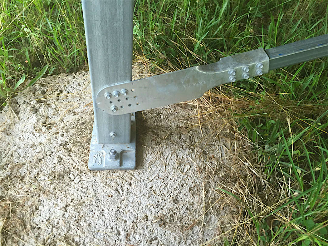 An Ezibrace Paddle fixed to an SHS post with screws above an Ezipier base on a concrete round footing