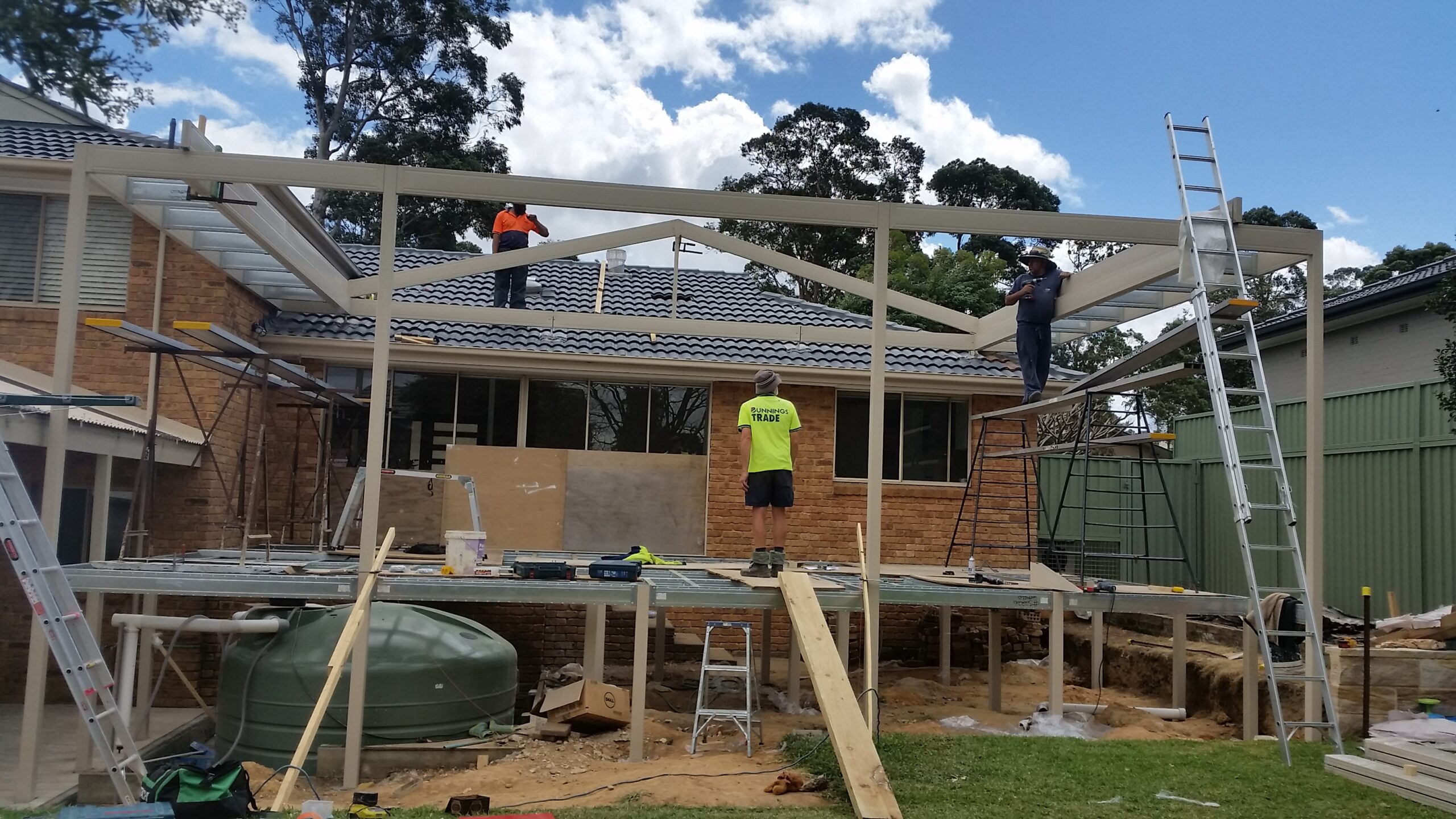 Boxspan deck and pergola frame under construction to existing house